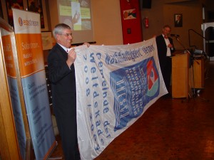 Bürgermeister Ernst und Professor de Haan entrollen die UN-Flagge für "ausgezeichnete" Gemeinden